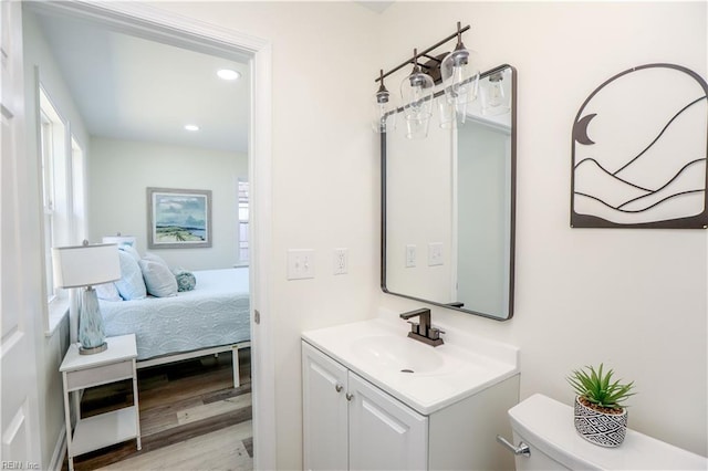 bathroom featuring vanity, wood-type flooring, and toilet