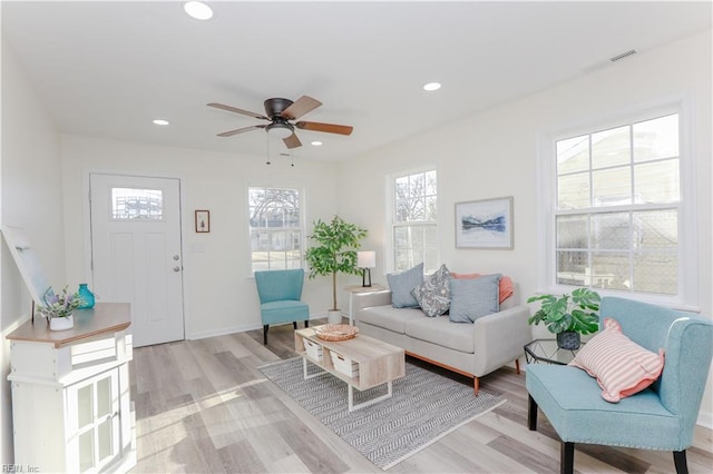 living room with light hardwood / wood-style flooring and ceiling fan