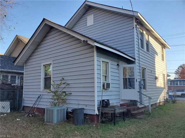 rear view of house with a lawn and cooling unit