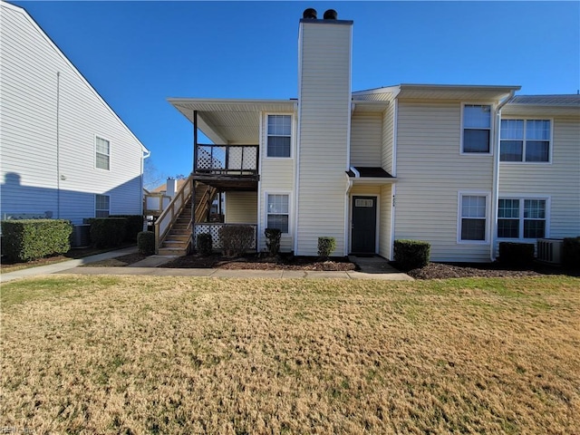 view of front of property with central air condition unit and a front lawn