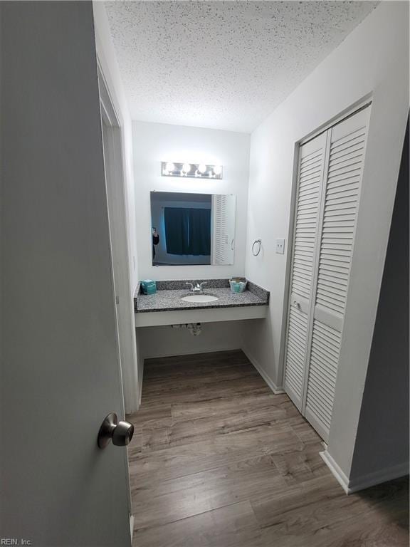 bathroom with vanity, wood-type flooring, and a textured ceiling