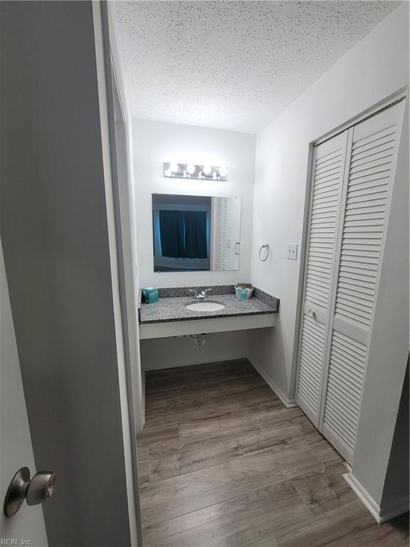 bathroom with vanity, wood-type flooring, and a textured ceiling