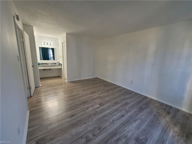 spare room featuring wood-type flooring and a textured ceiling