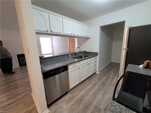 kitchen with sink, white cabinets, stainless steel appliances, and light wood-type flooring