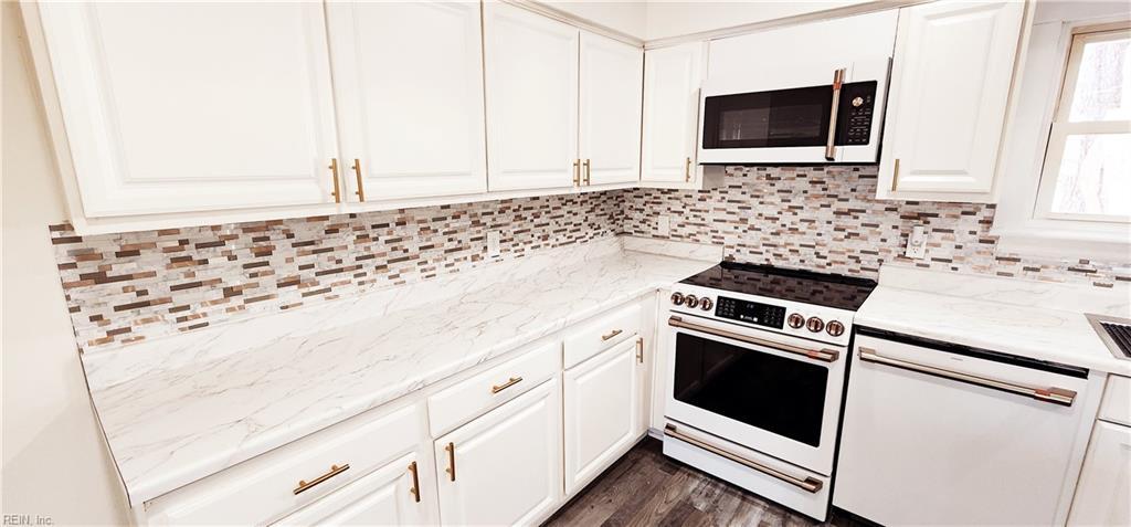 kitchen featuring white appliances, dark hardwood / wood-style floors, white cabinetry, and light stone counters