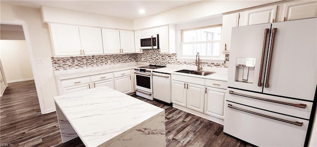 kitchen featuring white appliances, white cabinetry, and sink