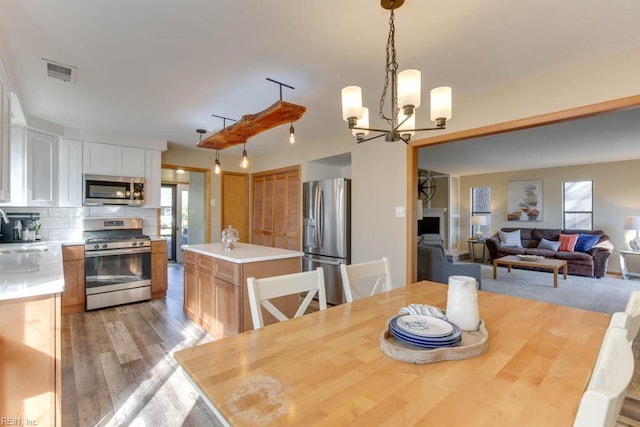 dining space with a chandelier, light wood-type flooring, and sink