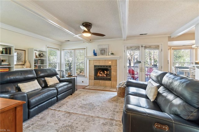 living room with french doors, ornamental molding, plenty of natural light, and a textured ceiling