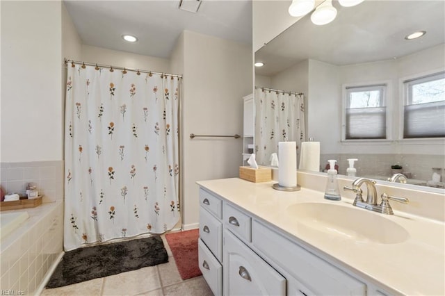 bathroom with tile patterned flooring, vanity, and tiled tub