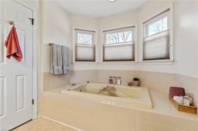 bathroom with tile patterned floors and tiled bath