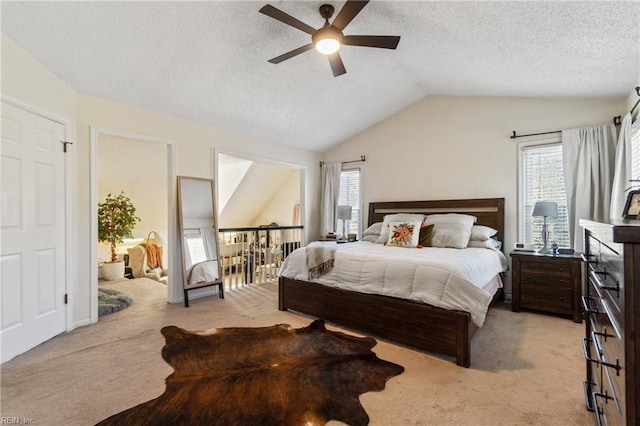 bedroom with ceiling fan, lofted ceiling, light carpet, and a textured ceiling