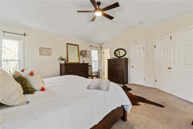 carpeted bedroom with vaulted ceiling and ceiling fan