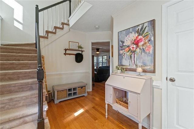 interior space featuring hardwood / wood-style flooring, ornamental molding, and a textured ceiling