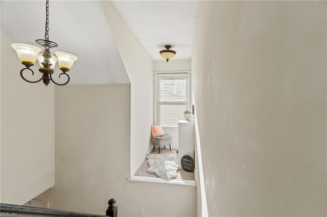 interior space with a notable chandelier and a textured ceiling