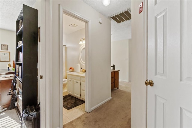 bathroom featuring vanity, a textured ceiling, and toilet