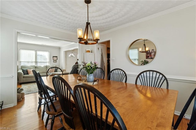 dining room featuring crown molding, a chandelier, and light hardwood / wood-style floors