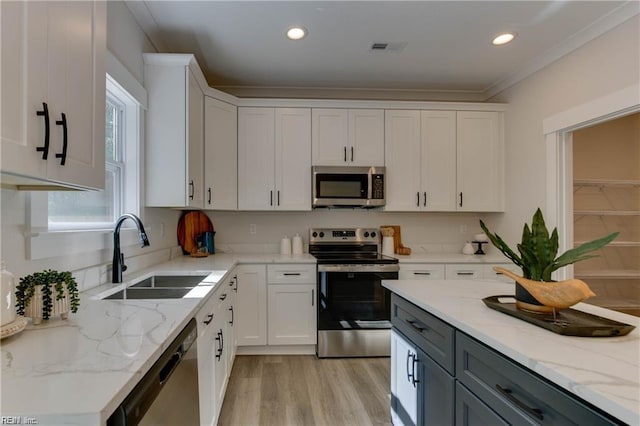 kitchen with sink, white cabinets, and appliances with stainless steel finishes