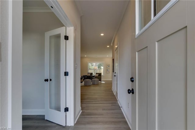 hallway featuring ornamental molding and light hardwood / wood-style flooring