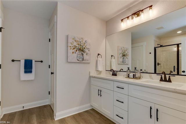 bathroom featuring hardwood / wood-style floors, vanity, and an enclosed shower