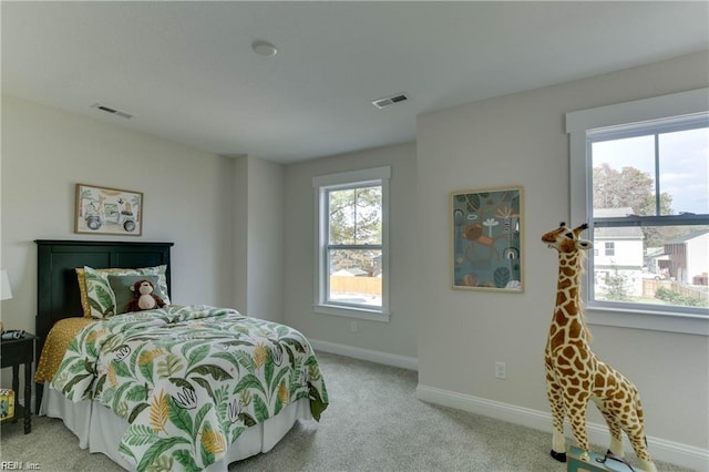 bedroom featuring multiple windows and light colored carpet