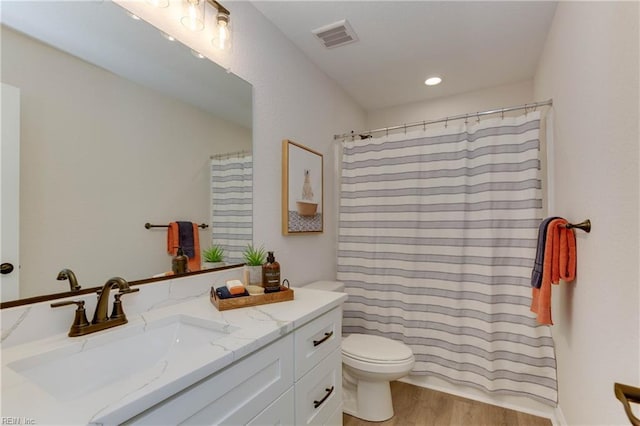 bathroom with a shower with curtain, vanity, toilet, and wood-type flooring