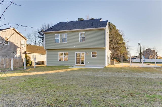 rear view of house with a lawn and central air condition unit