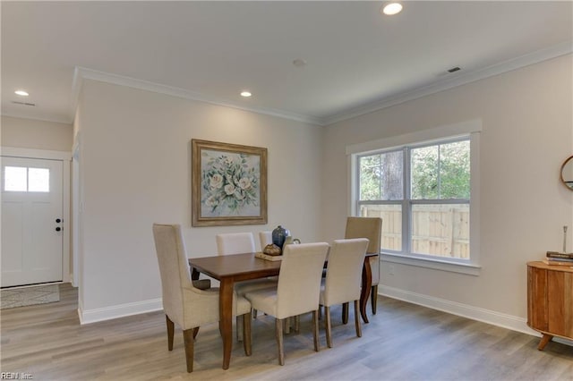 dining area with crown molding and light wood-type flooring