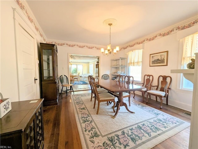 dining room featuring crown molding, dark hardwood / wood-style floors, and a notable chandelier