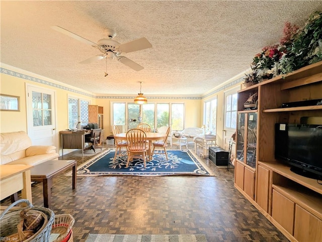 dining room with ceiling fan, ornamental molding, dark parquet floors, and a textured ceiling