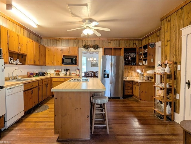 kitchen featuring sink, a kitchen island, stainless steel appliances, wood-type flooring, and a kitchen bar