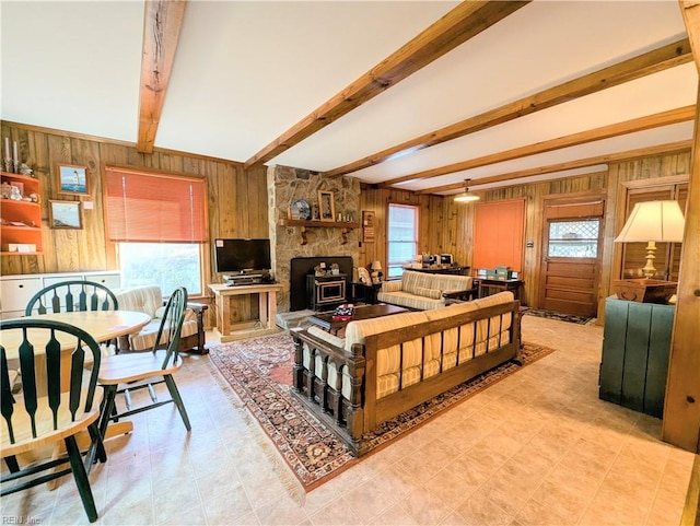 living room with beam ceiling, wooden walls, and plenty of natural light