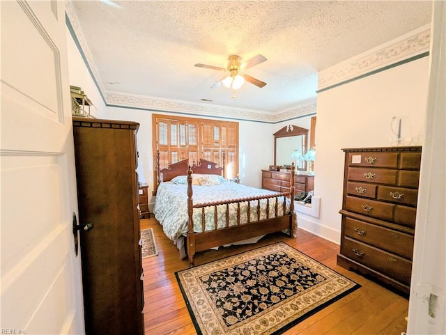 bedroom featuring ceiling fan, ornamental molding, a textured ceiling, and light hardwood / wood-style flooring