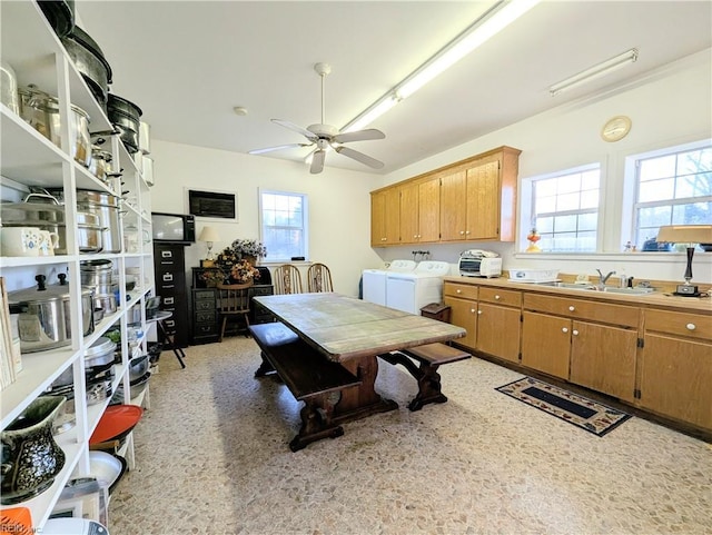 kitchen featuring sink, washing machine and clothes dryer, and ceiling fan