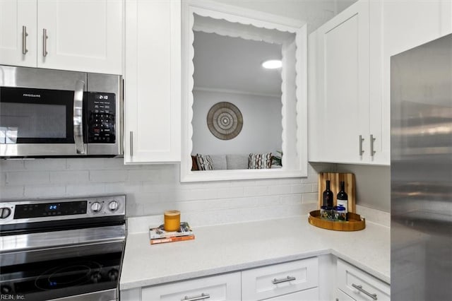 kitchen with appliances with stainless steel finishes, white cabinetry, and decorative backsplash