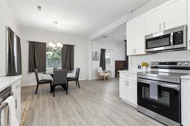 kitchen featuring a chandelier, stainless steel appliances, light countertops, and light wood-style flooring