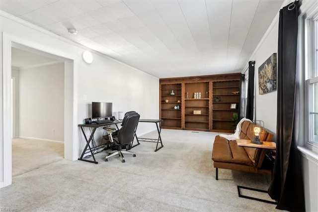 carpeted office space featuring baseboards and crown molding