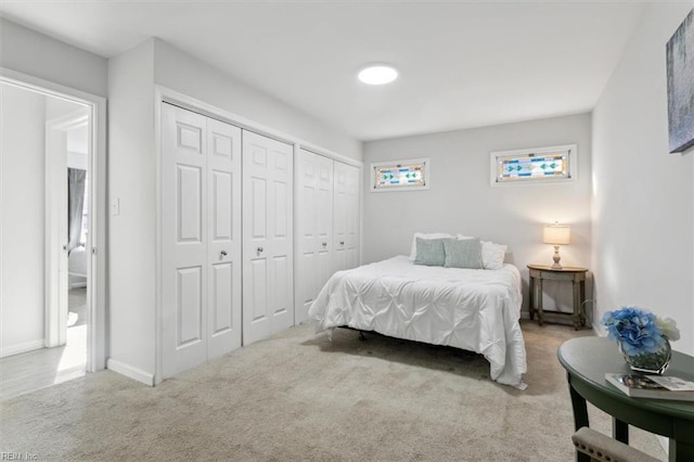 bedroom with carpet, baseboards, and multiple closets