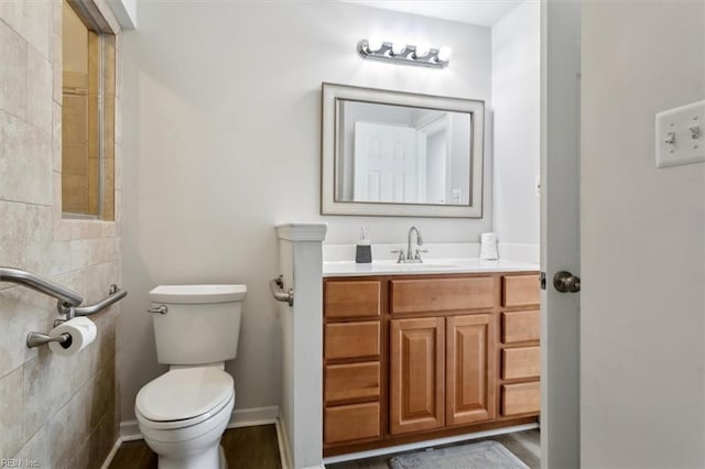 bathroom featuring vanity, toilet, and baseboards