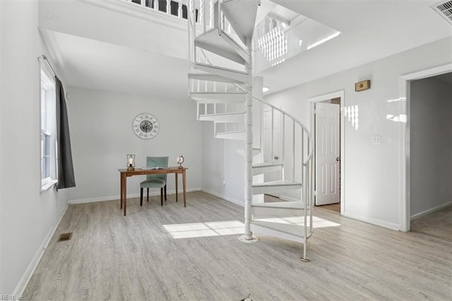 staircase featuring baseboards, visible vents, and wood finished floors