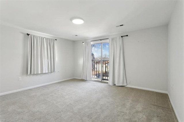 carpeted spare room with visible vents and baseboards