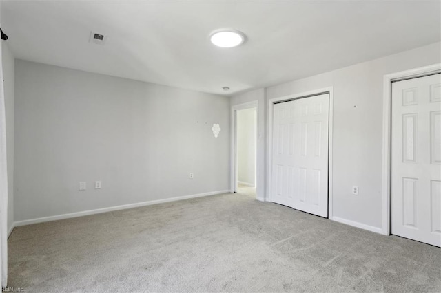 unfurnished bedroom with a closet, carpet flooring, visible vents, and baseboards