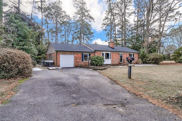 single story home featuring a garage and a front lawn