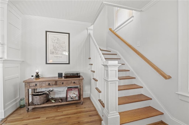 stairs featuring ornamental molding and wood-type flooring