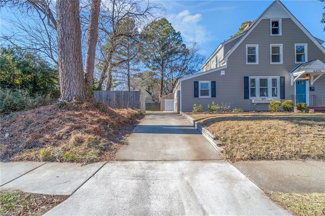 view of front of property with a garage, an outdoor structure, and a front lawn