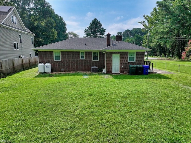 back of house with a yard and central AC unit