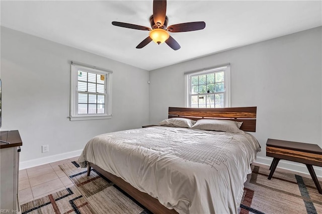 tiled bedroom featuring multiple windows and ceiling fan