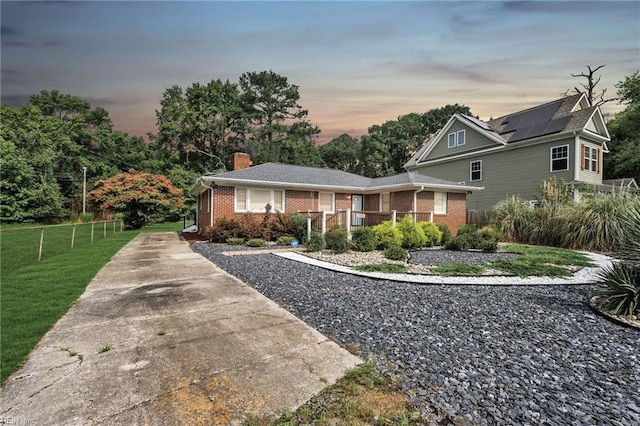 view of front of home with solar panels and a yard