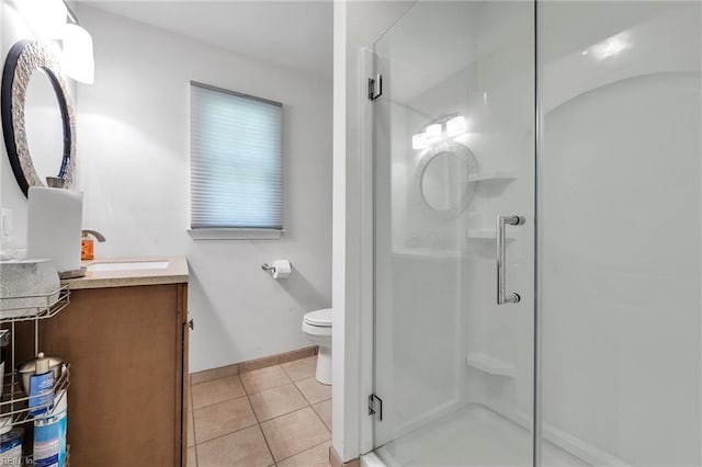 bathroom with tile patterned flooring, vanity, a shower with shower door, and toilet