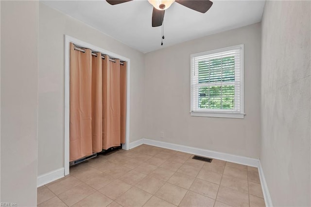 tiled empty room with ceiling fan