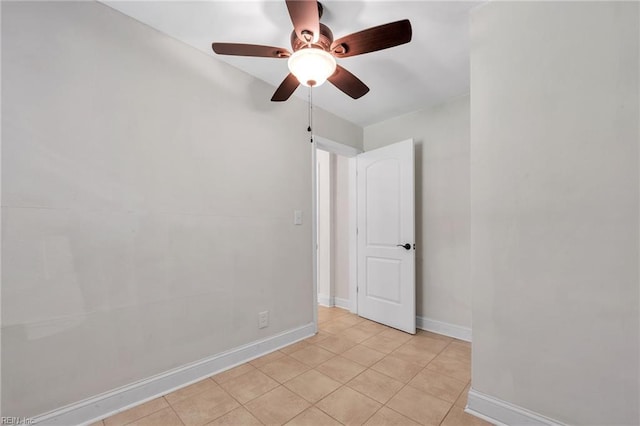 tiled empty room featuring ceiling fan